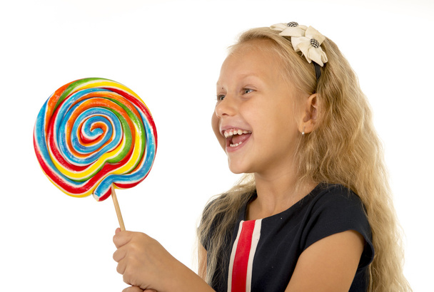 piękne dziecko kobieta z długimi blond włosami, jedzenie, lizanie, ogromny spirala lizak cukierki uśmiechający się zadowolony - Zdjęcie, obraz