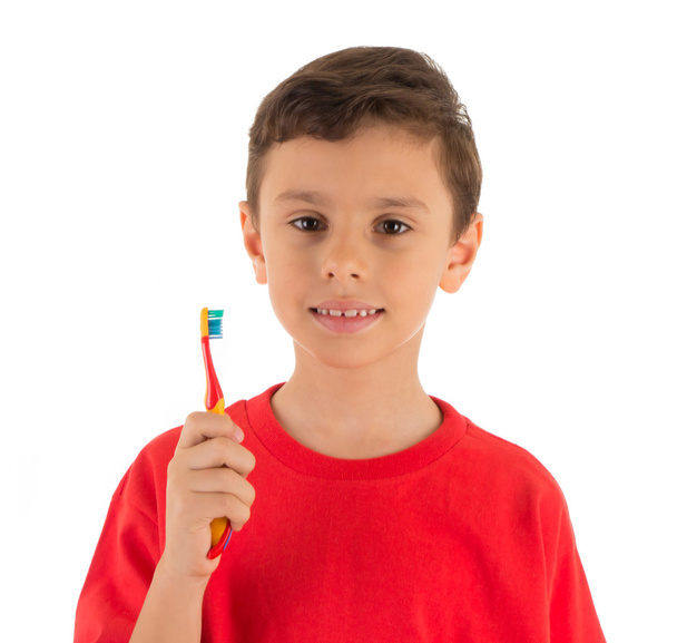 Niño sonriendo y sosteniendo un cepillo de dientes listo para cepillarse los dientes
 - Foto, imagen