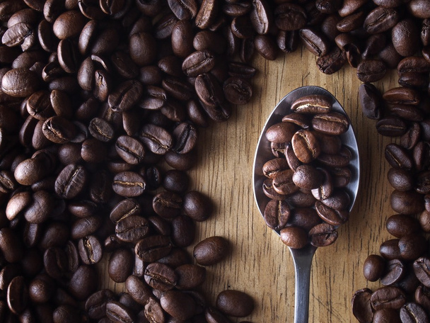 Grãos de café e uma colher com grãos de café
 - Foto, Imagem