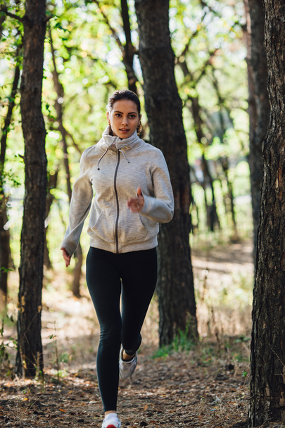 Runner woman jogging in autumn park - Foto, afbeelding