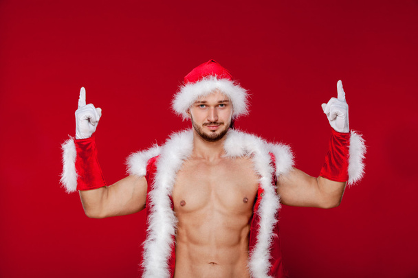 Sexy muscular man in santa uniform. Christmas New Year - Фото, изображение