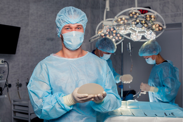 Team surgeon at work in operating room. breast augmentation. - Photo, image