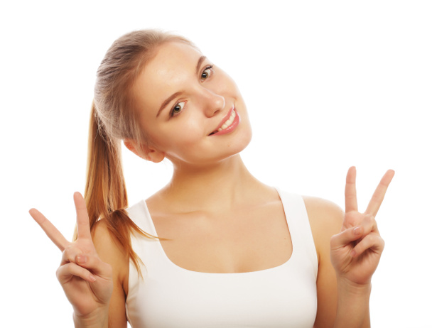портрет счастливой молодой женщины, дающей знак мира
 - Фото, изображение