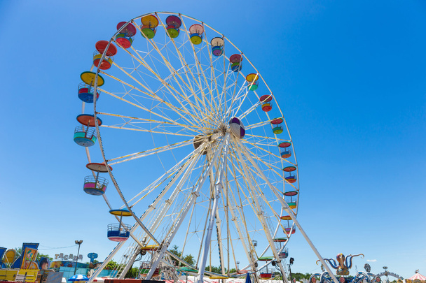Obří kolo v zábavním parku s modrou oblohou na pozadí - Fotografie, Obrázek