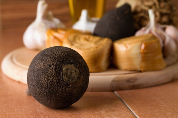Rábano negro frente a plato de madera con verdura
 - Foto, Imagen