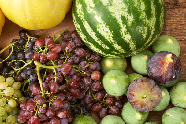 many fresh autumn fruits on wooden kitchen table - Photo, Image