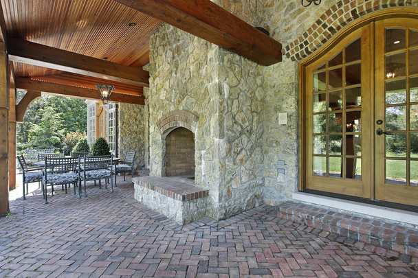 Patio de ladrillo con chimenea de piedra
 - Foto, imagen