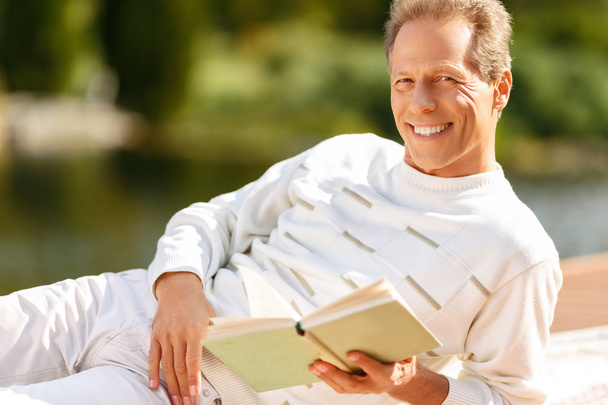 Agreeable man reading a book - Фото, изображение