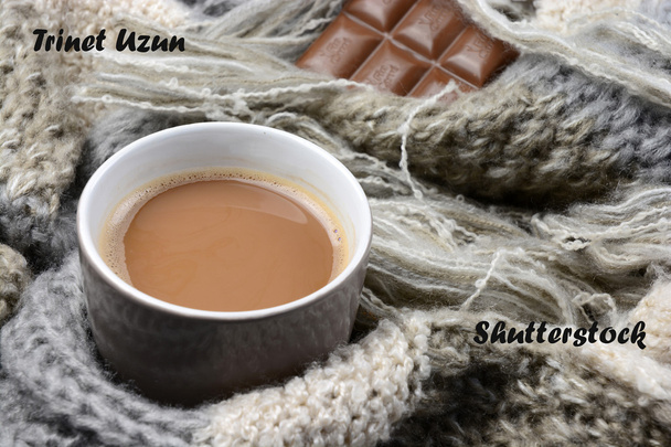 Ζεστή σοκολάτα σε κούπα καφέ με γκρι, ελεφαντόδοντο, εκρού Πλεχτό κασκόλ γύρω από αυτό και σοκολάτα - Φωτογραφία, εικόνα