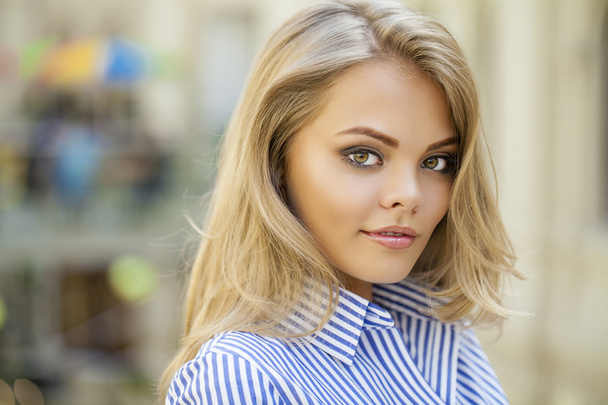 Portrait of a beautiful blonde in a blue striped shirt - Foto, afbeelding