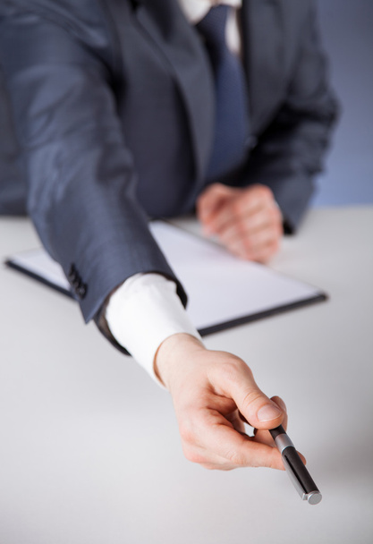 Businessman giving a pen to you - Photo, image