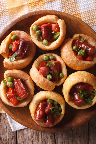Yorkshire puddings with sausage and vegetables closeup vertical - Zdjęcie, obraz