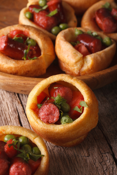 Yorkshire puddings stuffed with sausages close-up. Vertical - Zdjęcie, obraz