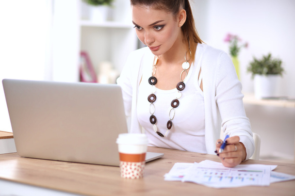 Portrait of a businesswoman sitting at  desk with  laptop - Φωτογραφία, εικόνα