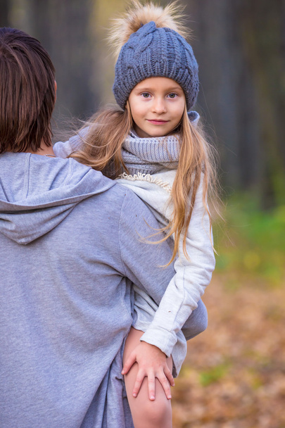 Little adorable girl with happy dad in autumn park outdoors - Photo, Image