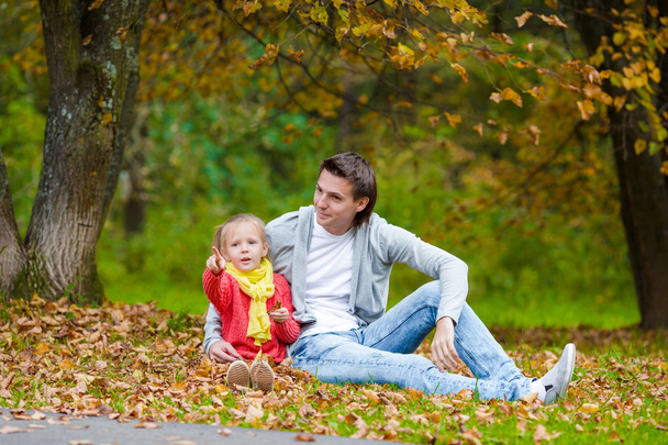 Schattig meisje met blij vader in herfst park buiten - Foto, afbeelding