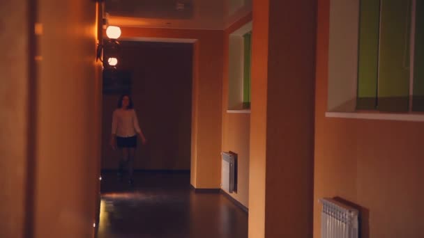 zaměstnanec hotelu vedoucí je žena večer podél koridoru žluté světlo - Záběry, video