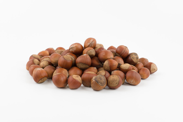hill of hazelnuts in a shell lies on a white background - Photo, Image