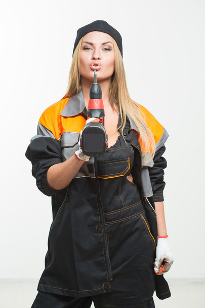 Young sexy female holding a cordless screwdriver - Fotoğraf, Görsel