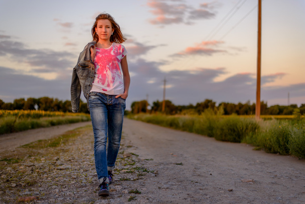 Jeune fille faisant une promenade en soirée à la campagne
 - Photo, image