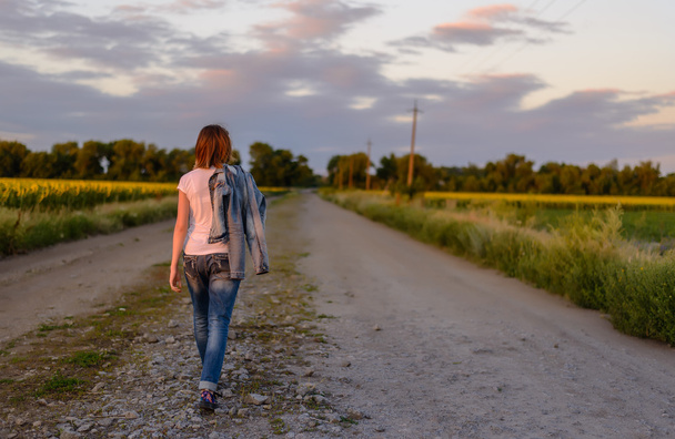 Kobieta, schodząc w dół drogi kraj - Zdjęcie, obraz