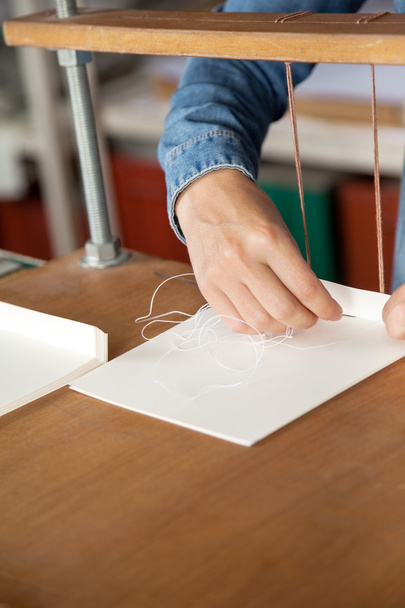 Arbeiter stecken Nadel per Hand in Papier - Foto, Bild
