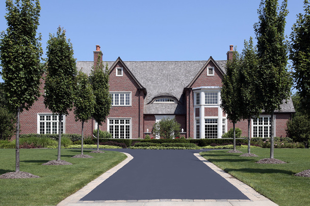 Large brick home with row of trees - Photo, Image