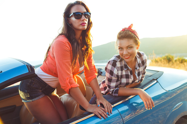 Deux jeunes filles s'amusent dans le cabriolet en plein air
 - Photo, image