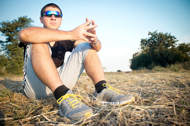 Portrait of a young athletic man on the ground - Фото, зображення