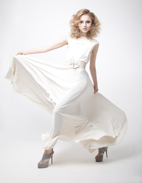 Lovely sensual young girl blond with flying white dress on podium - 写真・画像