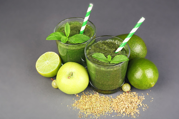 Green healthy juice with fruits and spices on gray background - Photo, image
