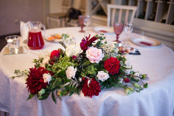 Interior do restaurante, grande mesa colocada para banquete, decorado em tons de Borgonha
 - Foto, Imagem