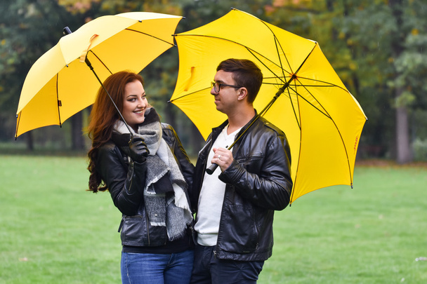 young couple in the autumn with an umbrella - Foto, afbeelding