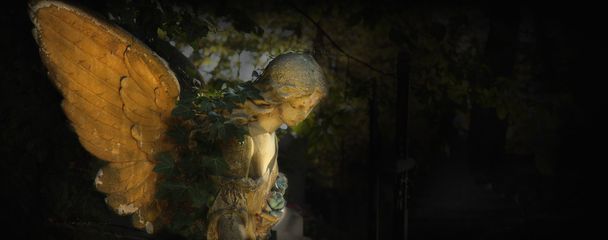 Imagen vintage de un ángel triste en un cementerio contra el fondo
 - Foto, imagen