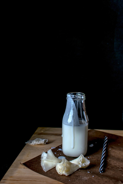 Tete de Moine Swiss Cheese et une bouteille avec boisson laitière sur fond noir
 - Photo, image