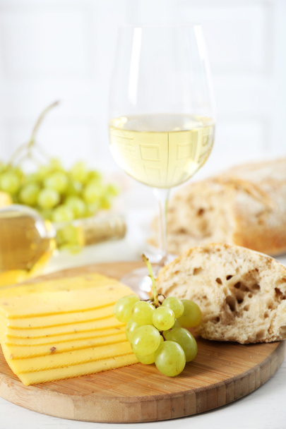 Still life of wine, grape, cheese and bread on light background - Фото, изображение