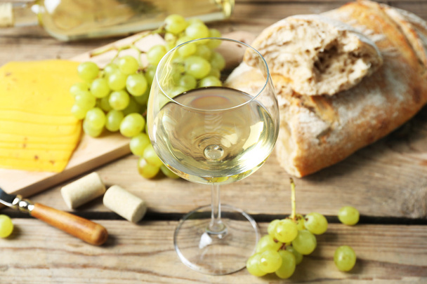 Still life of wine, grape, cheese and bread on rustic wooden background - Valokuva, kuva
