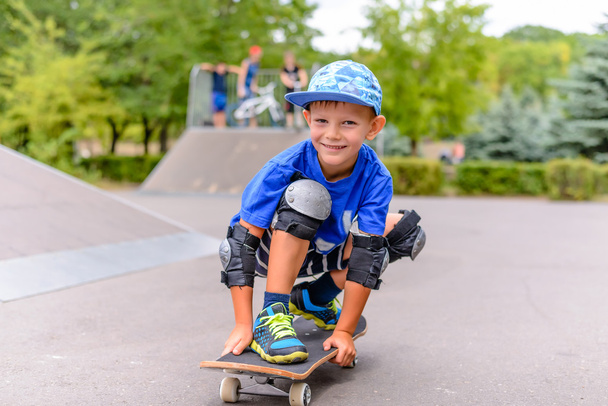 Malý chlapec na jeho skateboard, šklebil se na kameru - Fotografie, Obrázek