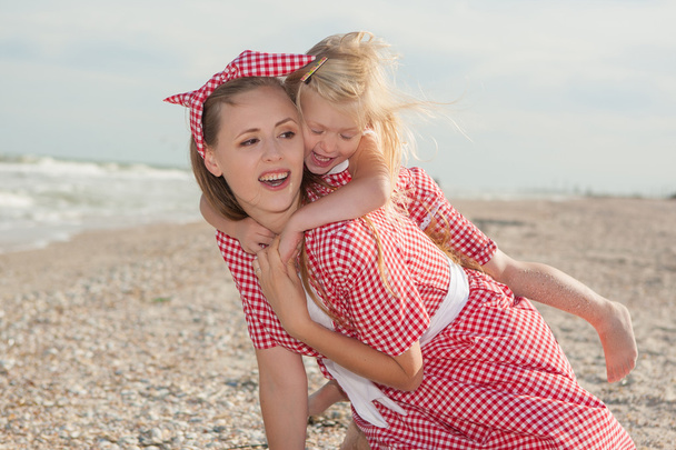Mutter und ihre Tochter amüsieren sich am Strand - Foto, Bild