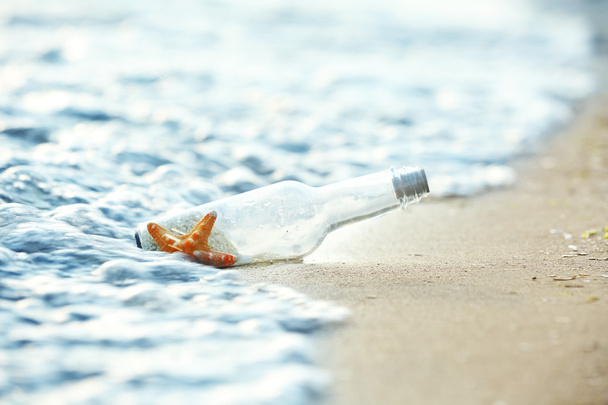 Bottle with starfish on beach - Foto, Bild