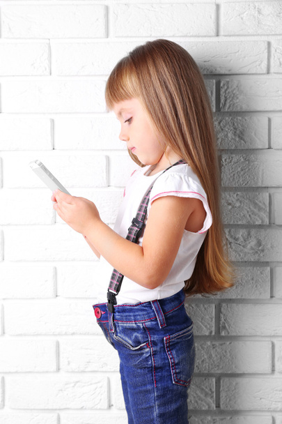 Beautiful little girl with mobile phone - Foto, Imagem