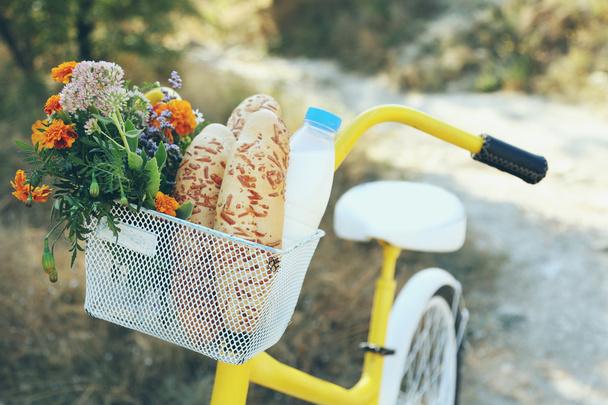 Fahrrad mit Blumen, Milchflasche und Brot - Foto, Bild
