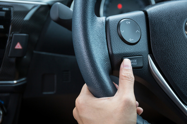 Ženská ruka tlačí tlačítko režim blokování ovládání na volantu. - Fotografie, Obrázek