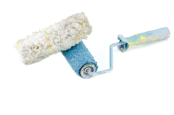 horizontal view creative image of dirty and reused white and blue roller paint brush with white feather placed in front. - Photo, Image