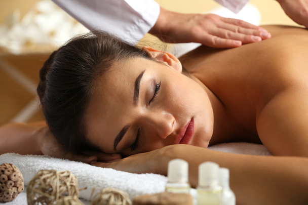 Jovem mulher na mesa de massagem no salão de beleza spa
 - Foto, Imagem