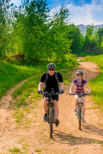 Мужчина-велосипедист в шлеме с рюкзаком и своей девушкой
 - Фото, изображение