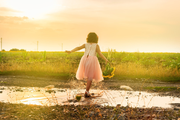 Cute little girl playing in puddle - Photo, Image
