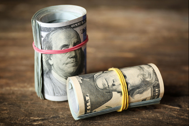 Dollars roll on wooden background - Foto, imagen