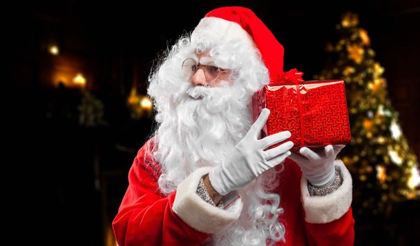Santa Claus guessing what's in box - Foto, afbeelding