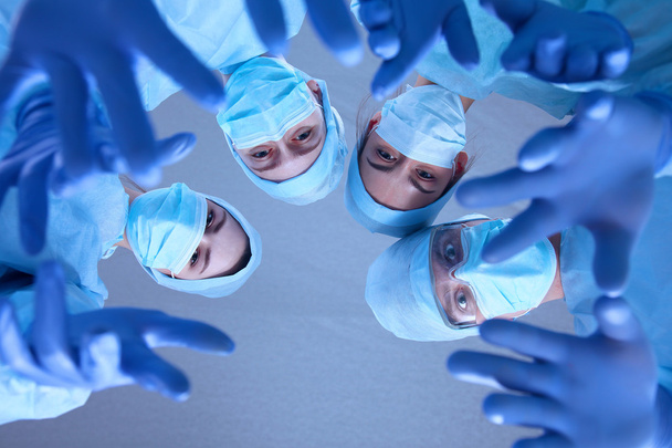 Surgeons team, wearing protective uniforms,caps and masks - Photo, Image